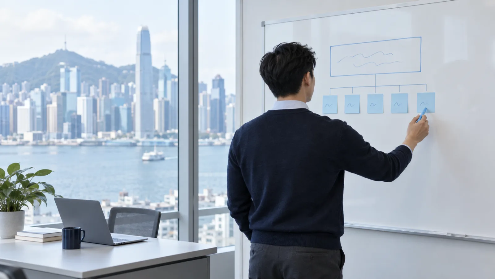 A professional mapping out a workflow on a whiteboard, with the harbour behind him